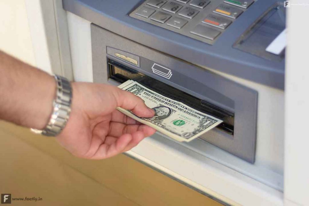 Withdrawing money in dollar from an atm.